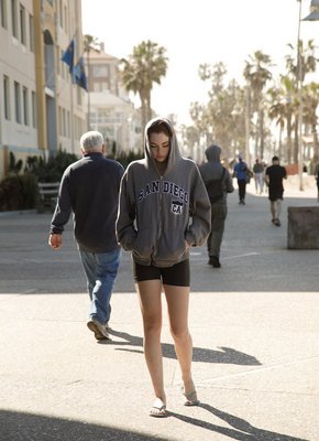 Рыженькая девушка в веснушках позирует на пляже